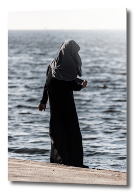 Young muslim girl walking at seaside