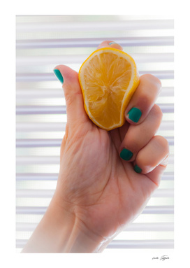 Woman's hand is squeezing a lemon