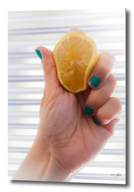 Woman's hand is squeezing a lemon