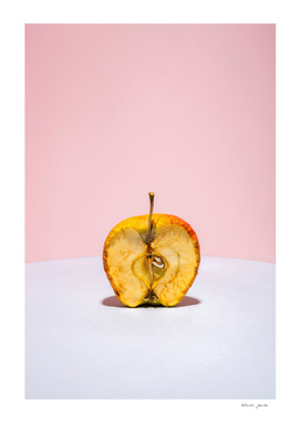 Old apple in a cut on a colored background
