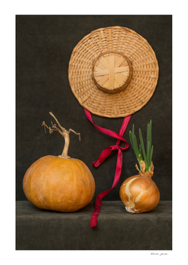Still life with pumpkin, hat and sprouted onions