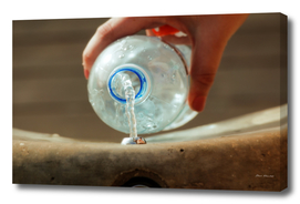 Female hand filling plastic water bottle