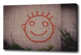 Graffiti painting of red happy smiley face on a concr