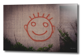 Graffiti painting of red happy smiley face on a concr