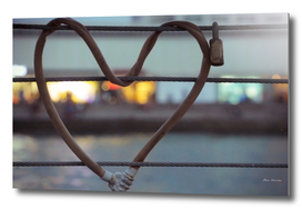 Heart-shaped padlock locked metal cables