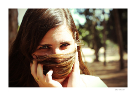 Woman hiding her face with her hair looking at camera