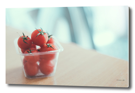Red tomatoes in plastic container