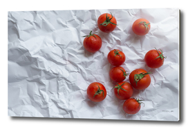 Red tomatoes on unfolded white paper