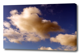 Dramatic Reddish Brown and white fluffy clouds in blue sky