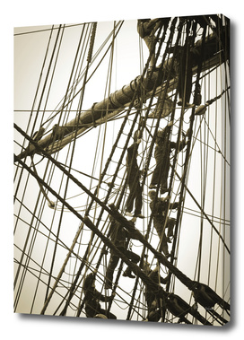 Sailors climbing in the rigging of a tall ship