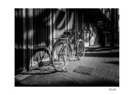Bicycle parked against the building black and white