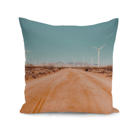 Wind turbine in the desert with sandy road