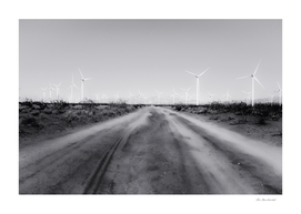 road in the desert with wind turbine in black and white