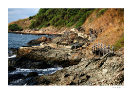 wooden walkway on rocky shore in the island