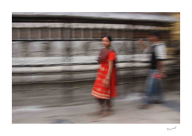Nepalese girl at prayer wheels