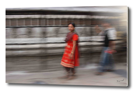 Nepalese girl at prayer wheels