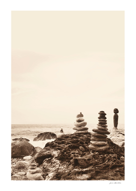 Monochrome aesthetic stacked beach stones on seaside rocks