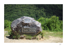Boulder With Train Station Sign