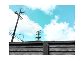electric pole with wood wall and blue cloudy sky in the city