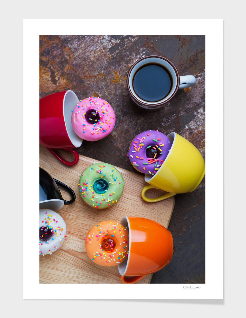 Colorful fancy donuts with black coffee