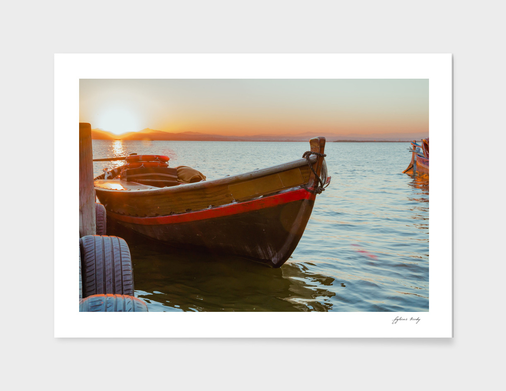 Sunset on the lake. Old lake fishing boat. Spain