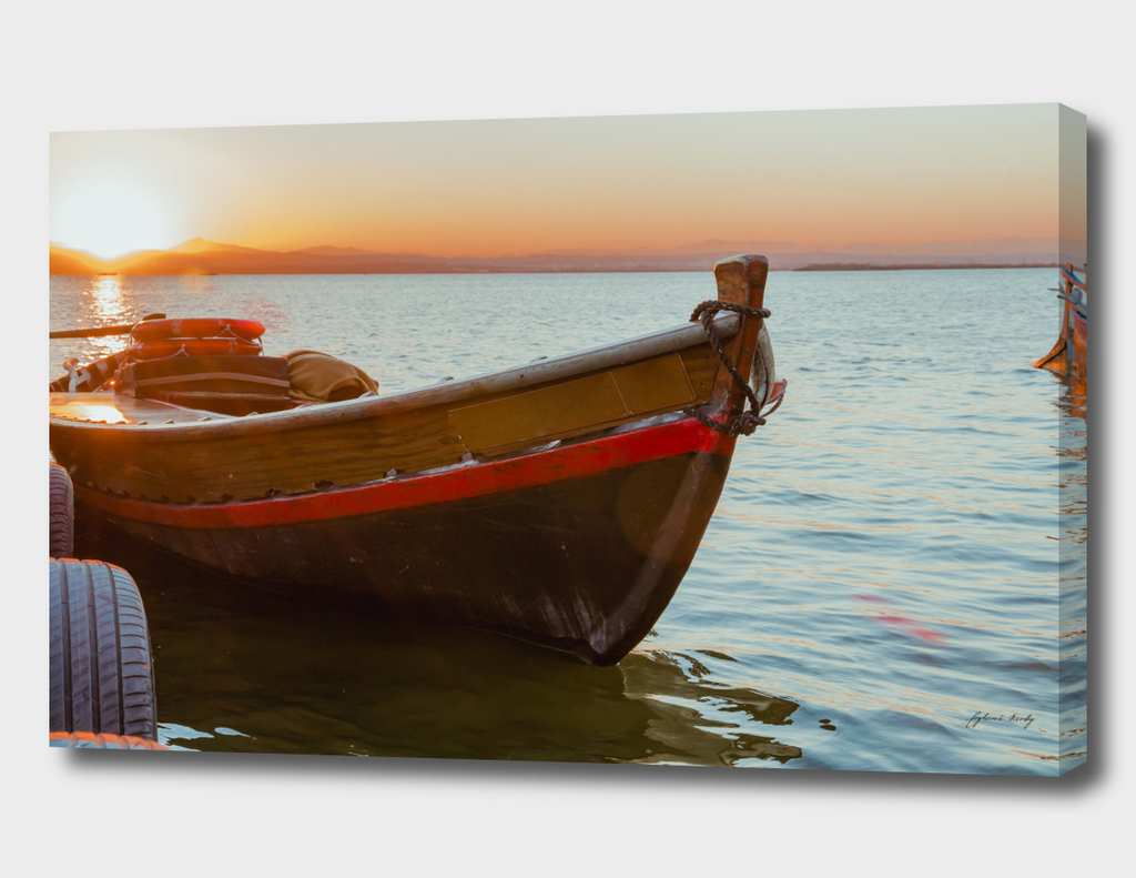 Sunset on the lake. Old lake fishing boat. Spain