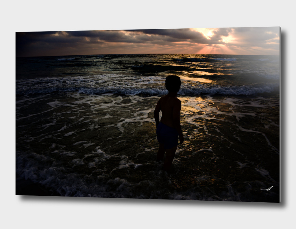 Young boy looking at the sunset