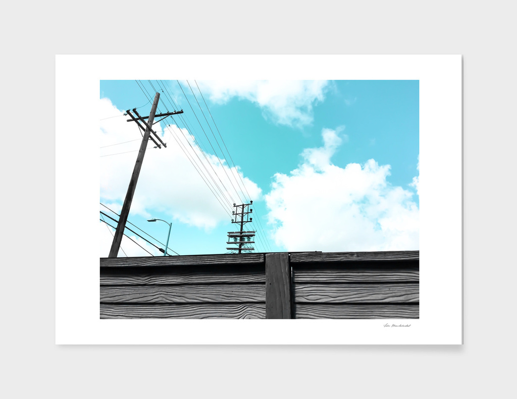 electric pole with wood wall and blue cloudy sky in the city